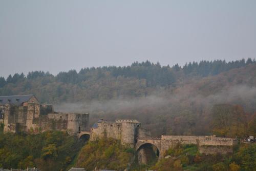 an old castle on a hill with a bridge at Maison D'ide in Bouillon