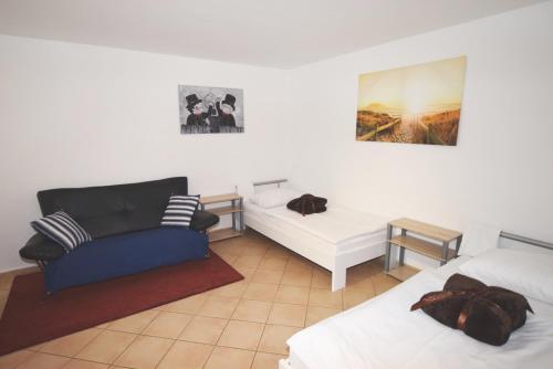 シュトゥットガルトにあるApartment Stuttgart Münsterのベッド2台、ソファ、椅子が備わる客室です。