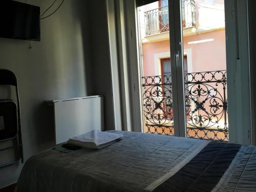 a bedroom with a bed and a window with a balcony at Pensión La Bilbaina - Albergue Logroño in Logroño