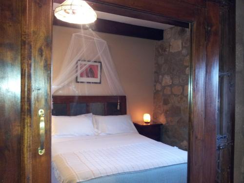 a bedroom with a bed with a wooden door at Hotel Rural San Pelayo in San Pelayo