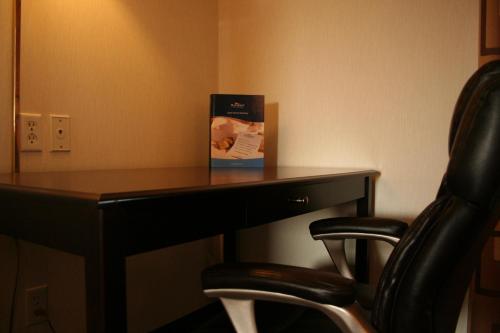a book sitting on top of a desk with a chair at Baymont by Wyndham Battle Creek Downtown in Battle Creek