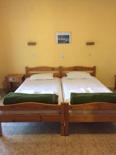 two wooden beds in a room with at Avgoustina Venus Studios in Benitses