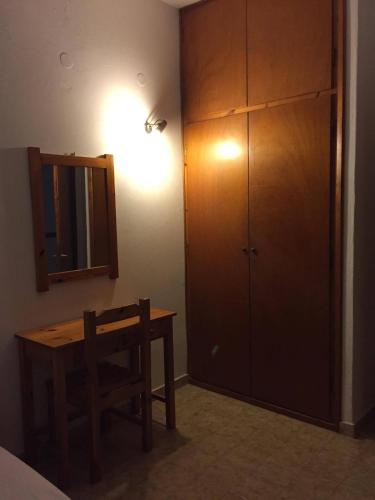 a bedroom with a table and a mirror and a cabinet at Avgoustina Venus Studios in Benitses