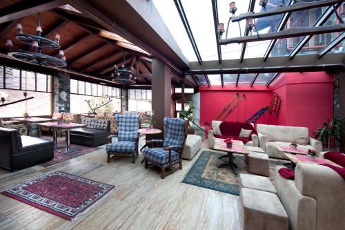 a large living room with pink walls and furniture at Chalet Lithos in Palaios Agios Athanasios