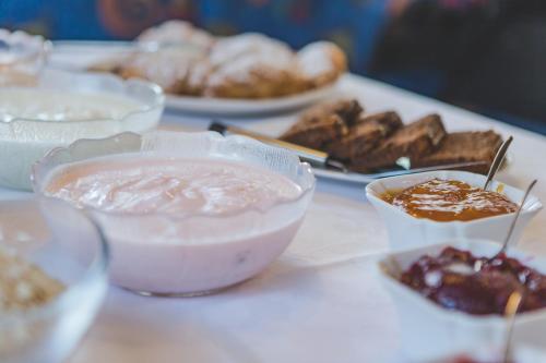 a table topped with bowls of food and pastries at Garni Appartement Alpenresidence in Cadipietra