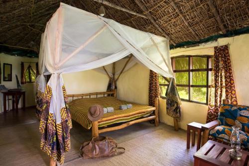 a bedroom with a canopy bed in a room at Selous River Camp in Kwangwazi