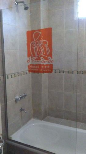 a bathroom with a bath tub with a sign on the wall at Del Fundador in Córdoba