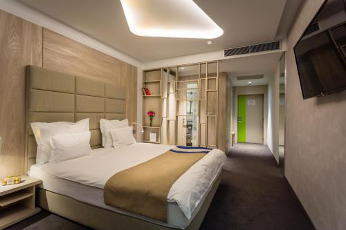 فندق كولورز إن سراييفو في سراييفو: غرفة نوم بسرير كبير وتلفزيون