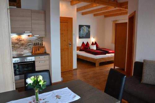 uma cozinha e sala de estar com uma mesa e um sofá em Appartement Herzog em Saalfelden am Steinernen Meer