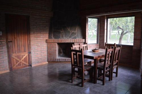 a dining room with a table and chairs and a fireplace at Complejo Arlington Village in Cortaderas