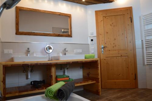 uma casa de banho com um lavatório, um espelho e uma banheira em Appartement Herzog em Saalfelden am Steinernen Meer