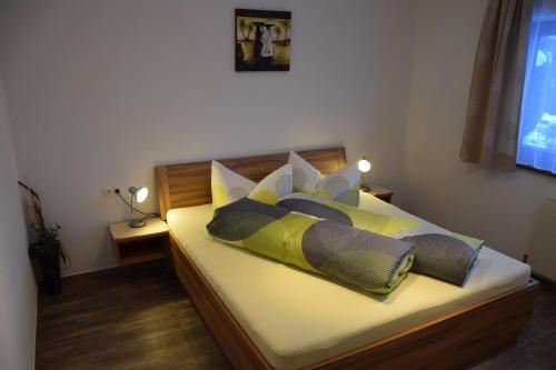 a bedroom with a bed with four pillows on it at Ferienwohnung Auderer Monika in Jerzens