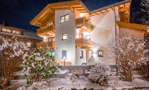 a large white building with snow in front of it at Apart Dengg in Mayrhofen