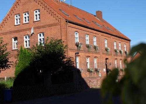 a large red brick building with windows and plants at Alte Schule Schnackenburg in Schnackenburg