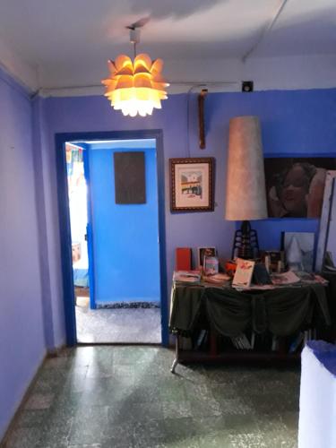 une chambre bleue avec une table et une porte bleue dans l'établissement Hotel Asmara, à Chefchaouen