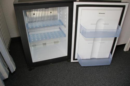 einem leeren Kühlschrank mit offener Tür in einem Zimmer in der Unterkunft Schlaf(t)raum in Berlin