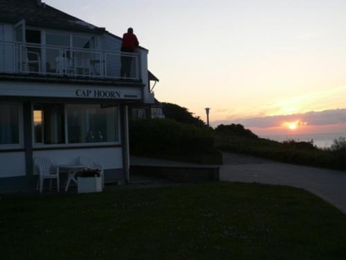 a man sitting on the balcony of a city room at Gaestehaus Cap Hoorn in Helgoland