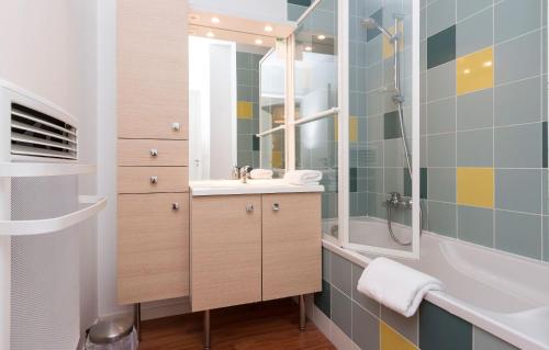 een badkamer met een wastafel en een douche bij Résidence Odalys Fleur de Sel in Guidel-Plage
