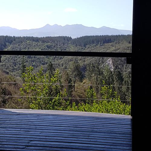a view of the mountains from a wooden deck at Forest Valley Cottages in Knysna