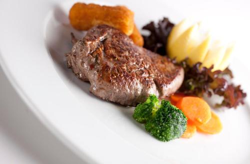 a plate of food with a piece of meat and vegetables at Brunnerhof Klausen-Chiusa in Chiusa