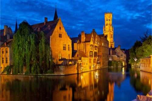 an old building with a clock tower next to a river at Hotel Approach in Knokke-Heist