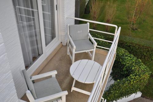 a porch with two chairs and a table and a window at Hotel Approach in Knokke-Heist