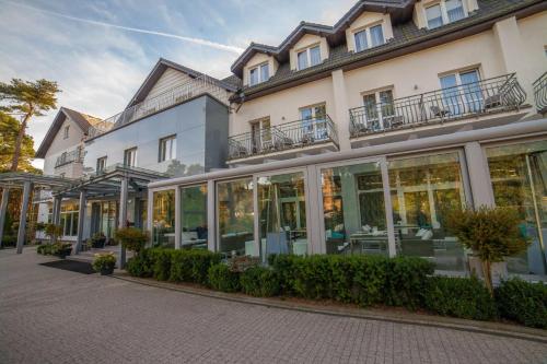 a large building with glass doors and windows at Hotel Jantar Wellness & Spa in Ustka