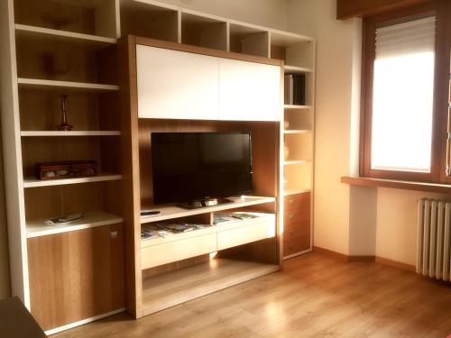 a living room with a tv in a book shelf at Residenza Bouganville in Torri del Benaco