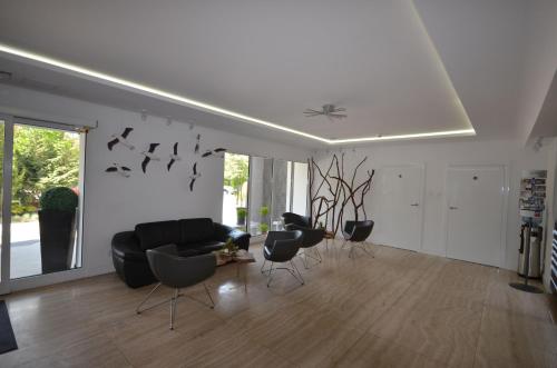 a living room with a black couch and chairs at Hotel Jantar Wellness & Spa in Ustka