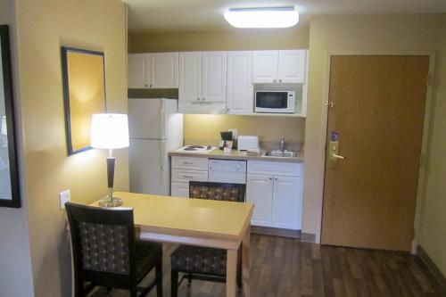 a kitchen with a table and chairs and a kitchen with white cabinets at Extended Stay America Suites - Seattle - Bothell - Canyon Park in Bothell