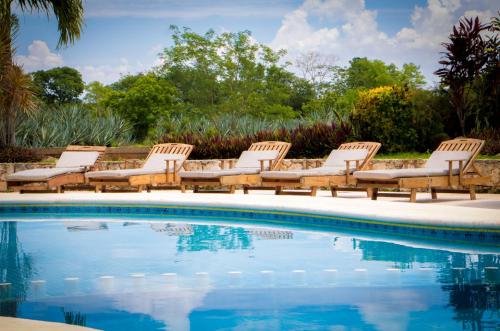 a group of chairs and a swimming pool at Hacienda Viva Sotuta de Peón in Tecoh