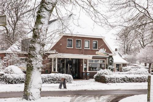 a house covered in snow in front at De Herberg van Anderen in Anderen