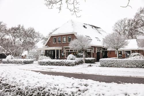 a house is covered in snow at De Herberg van Anderen in Anderen
