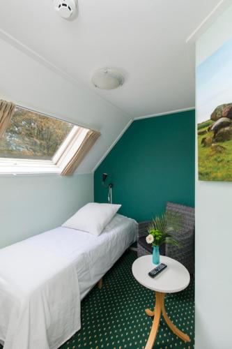 a bedroom with a bed and a table and a window at De Herberg van Anderen in Anderen
