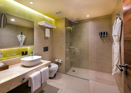 a bathroom with a shower and a sink and a toilet at Occidental Punta Cana - All Inclusive in Punta Cana