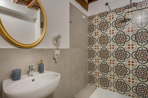 bagno con lavandino e specchio di Residenze d'epoca Collection-Sant'Anna a Firenze