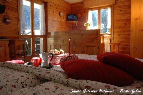 サンタ・カテリーナ・ヴァルフルヴァにあるBaita Stelvioのベッドルーム1室(赤い枕のベッド1台付)