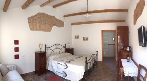 een slaapkamer met een bed en een bank bij La Casetta nel Borgo in Faenza
