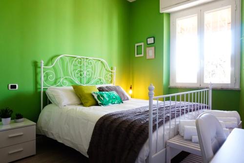 um quarto com paredes verdes e uma cama branca em Villa Aurelia - Seafront Apartment with Terrace em Flumini di Quartu