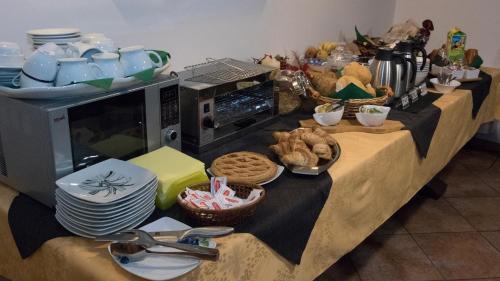 a buffet with plates and bowls and a microwave at VillaRosa in Santa Lucia di Piave