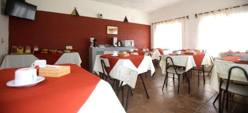 een restaurant met rode en witte tafels en stoelen bij Perla del Este in La Paloma