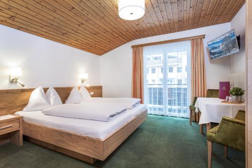 a hotel room with a bed and a large window at Pension Margarete in Zell am See