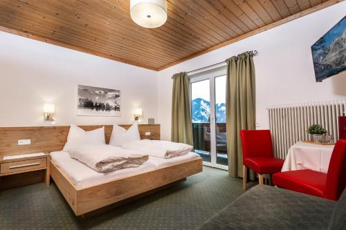 a hotel room with a bed and a chair at Pension Margarete in Zell am See
