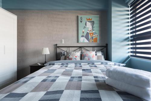 ein Schlafzimmer mit einem großen Bett mit blauen Wänden in der Unterkunft LiveGRACE Apartment Xindian in Xindian