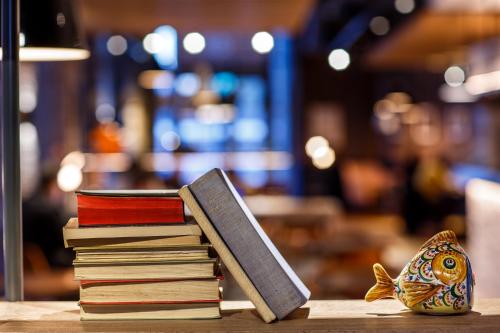 a pile of books sitting on top of a table at ibis London Canning Town in London