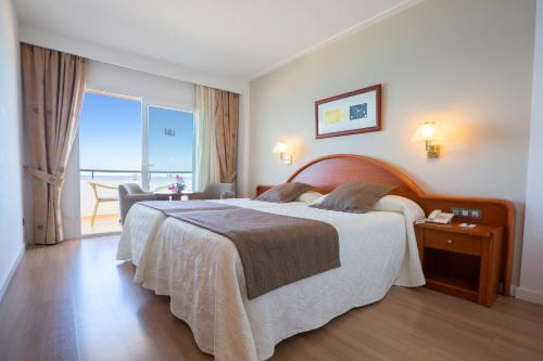 カラ・ミラーにあるヒポテルス ヒポカンポ プラヤの大きなベッドとバルコニーが備わるホテルルームです。