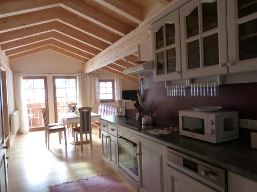 a kitchen with white cabinets and a table with a microwave at Berghütte Schöpf in Umhausen
