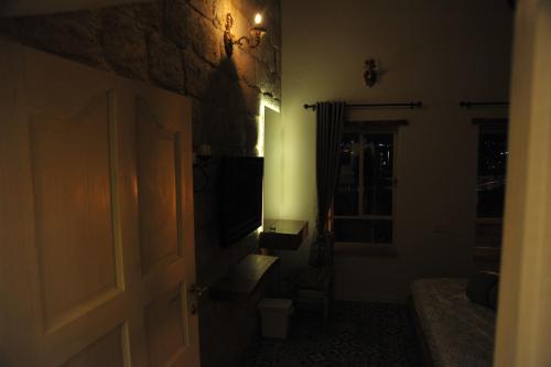 a dark room with a door and a television at Aleen Guest House in Nazareth