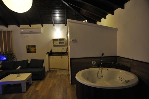 a large bath tub in a living room with a couch at Aleen Guest House in Nazareth