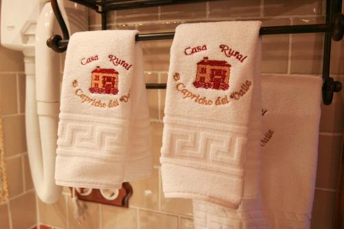 two white towels hanging on a rack in a bathroom at Casa Rural Capricho del Valle in Arroyo Frio